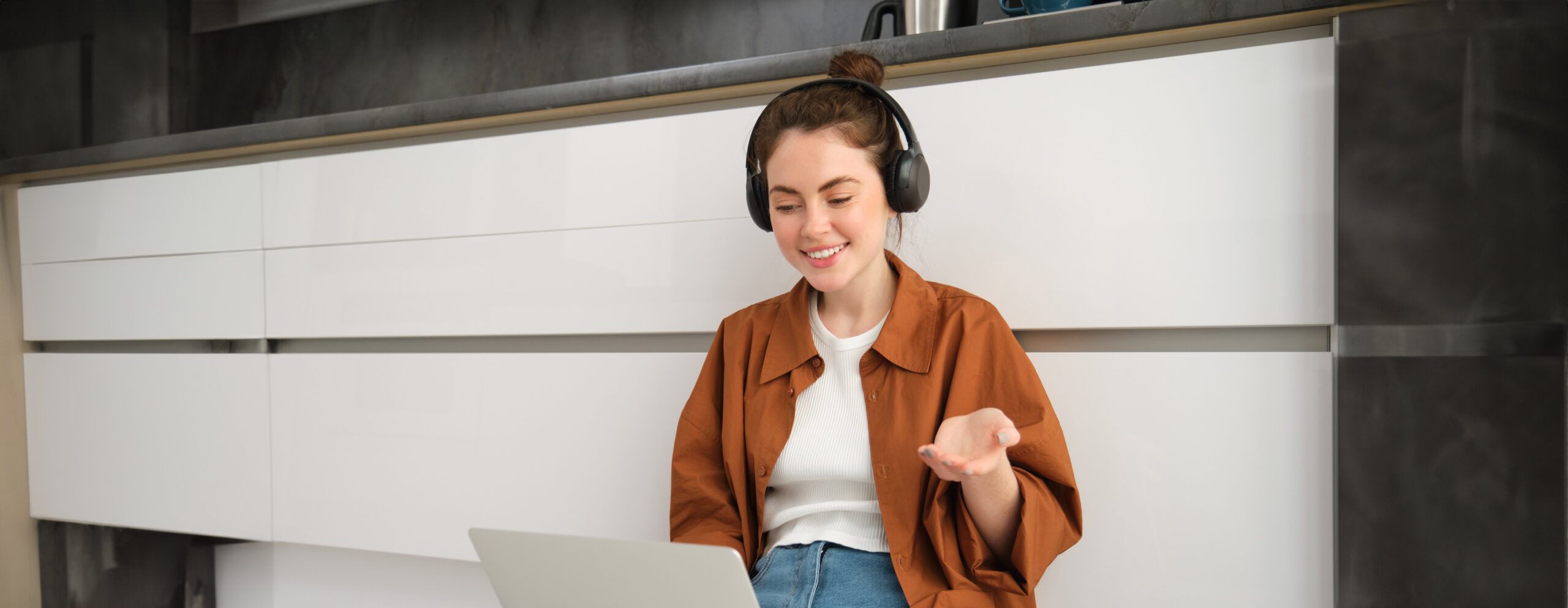 portrait-young-smiling-woman-explains-something-video-call-sits-headphones-with_11zon